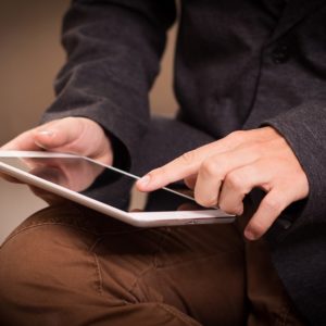 man tapping on tablet