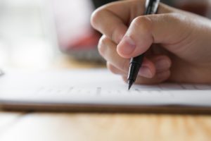 Hand writing on paper with pen